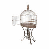 Fémből készült, ovális formájú, barna színű, 70 cm hosszú és 142 cm magas, díszes lábakon álló, vintage stílusú madárkalitka.